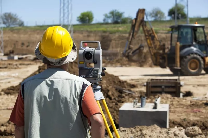 Surveyor with rover on construction site