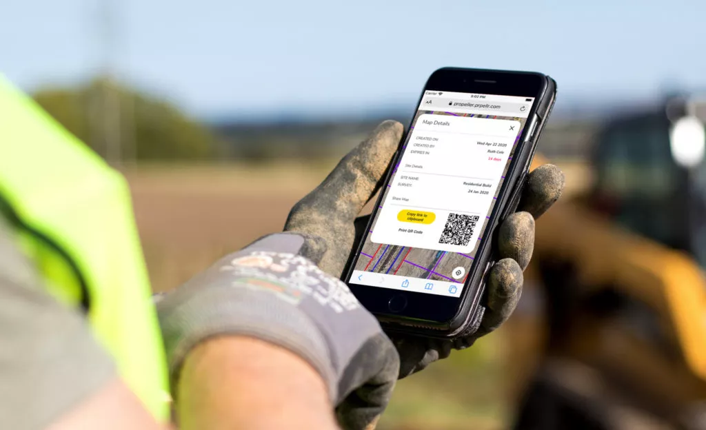 construction worker looking at QR code on cell phone