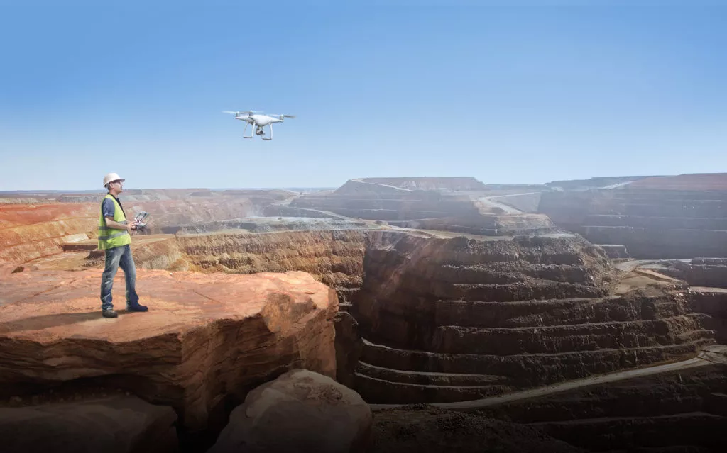 construction worker flying drone over canyon