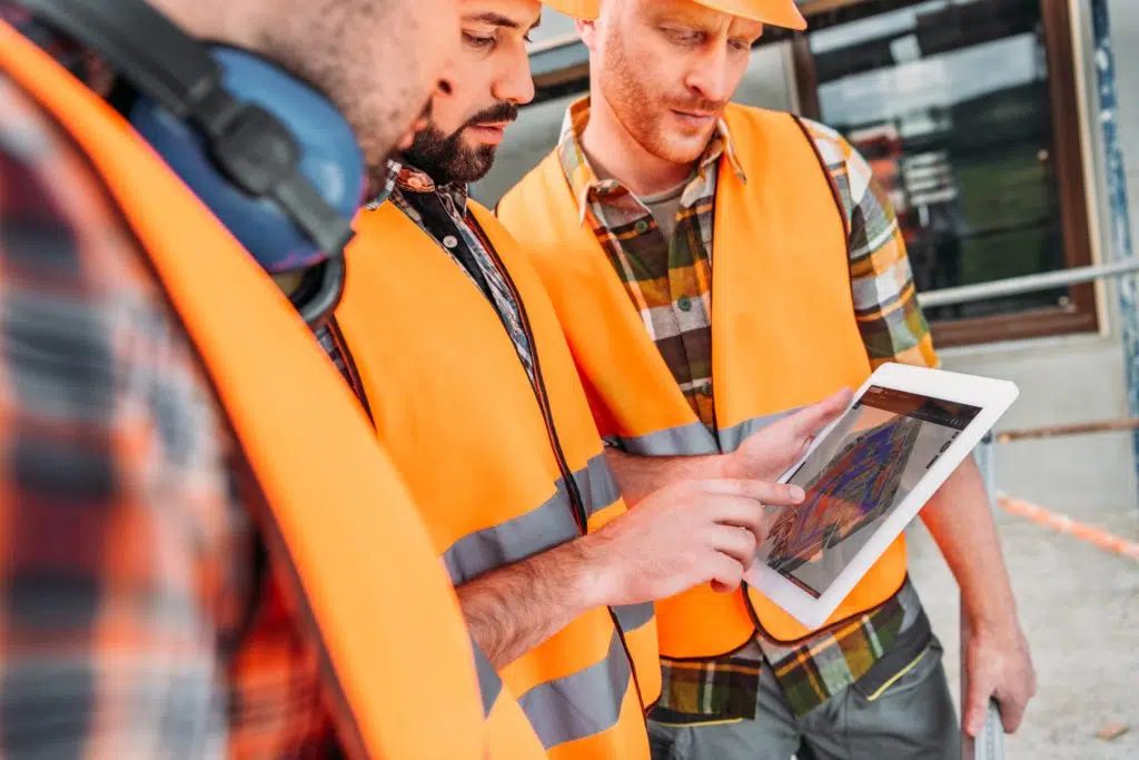 construction workers looking at computer screen